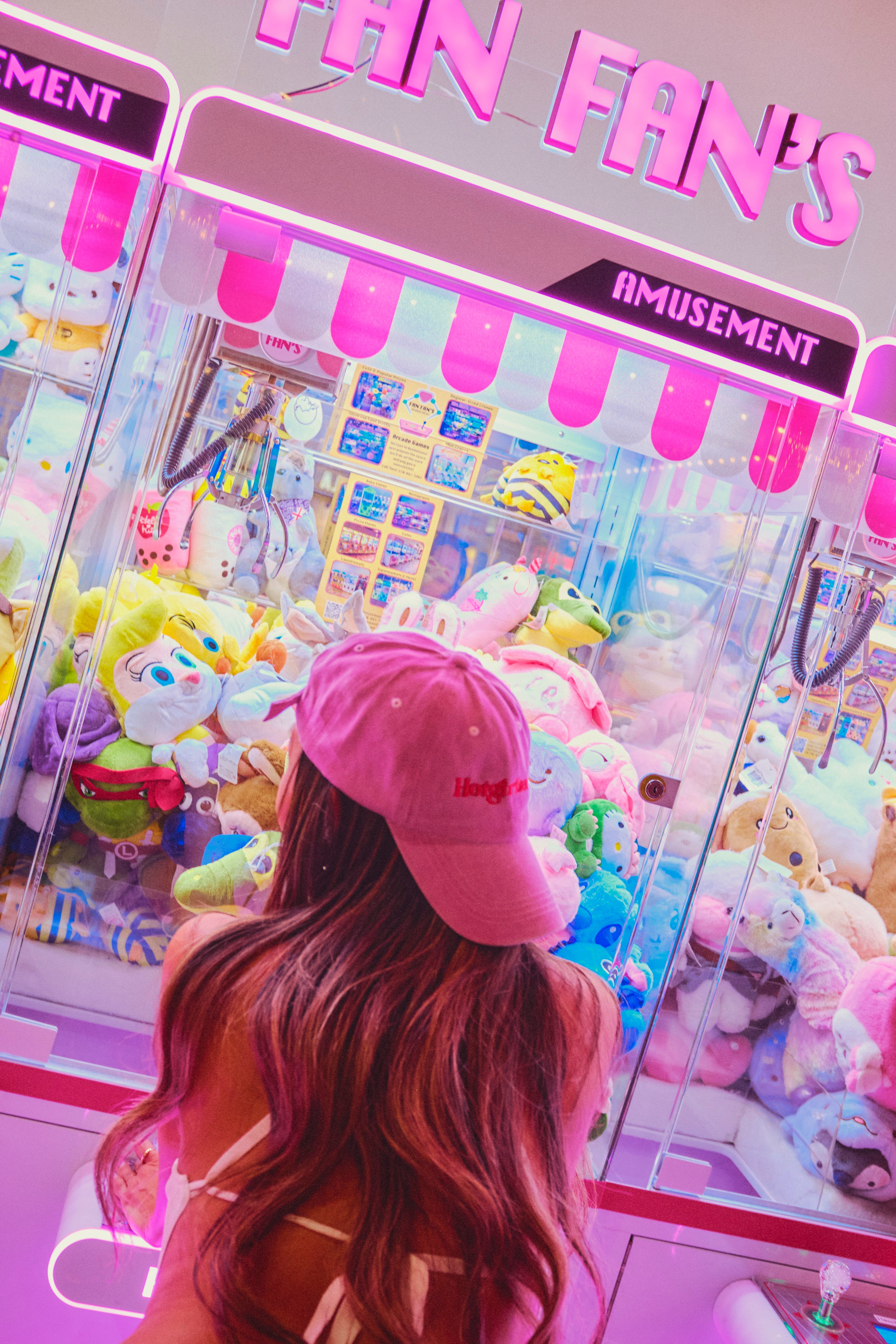 Back view of pink Hotgirlsauce hat worn in neon arcade setting